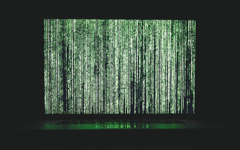 Laptop With Green Data on a Dark Background